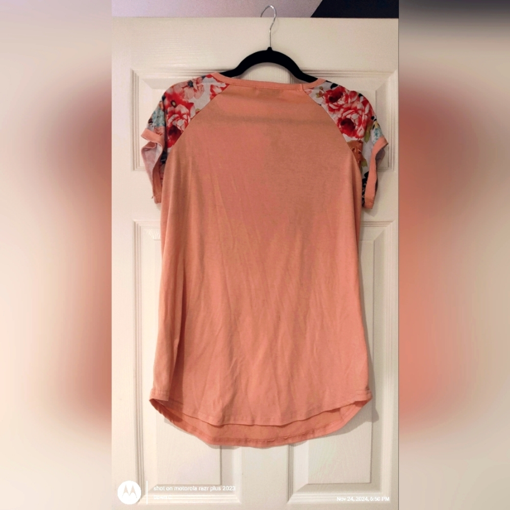 Peach-colored short-sleeve top with floral patterned sleeves.